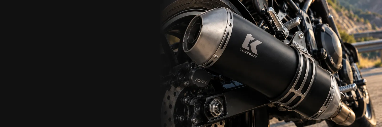 Escape Turbo Kit negro con el logotipo grabado, montado en una moto